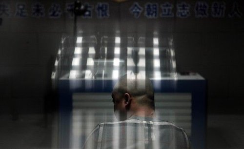 坐在审问室的涉案嫌疑人等待审问。
