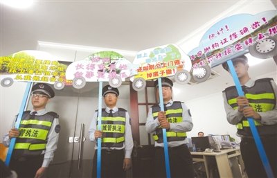 17日,武汉市城管局组织执法队员举牌上门来到神州租车武汉分公司催缴车窗抛物罚款。